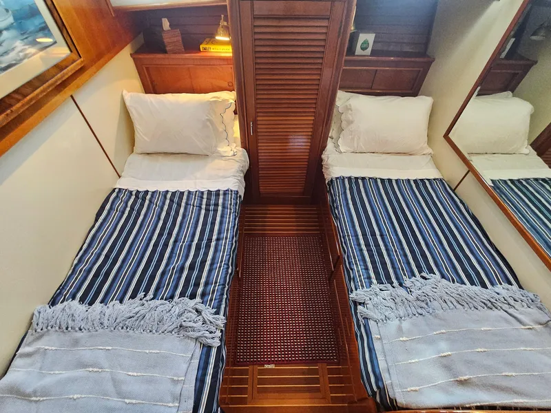 Slide: The Image of Twin beds with striped bedding in a 2002 Grand Banks 49 Eastbay HX cabin. - 42