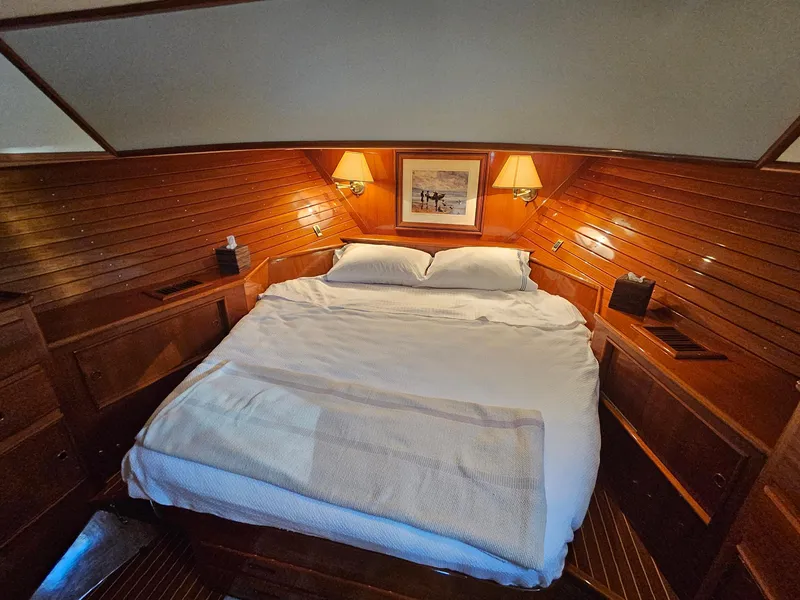 Slide: The Image of Luxurious cabin interior of 2002 Grand Banks 49 Eastbay HX yacht with cozy bed and warm lighting. - 48