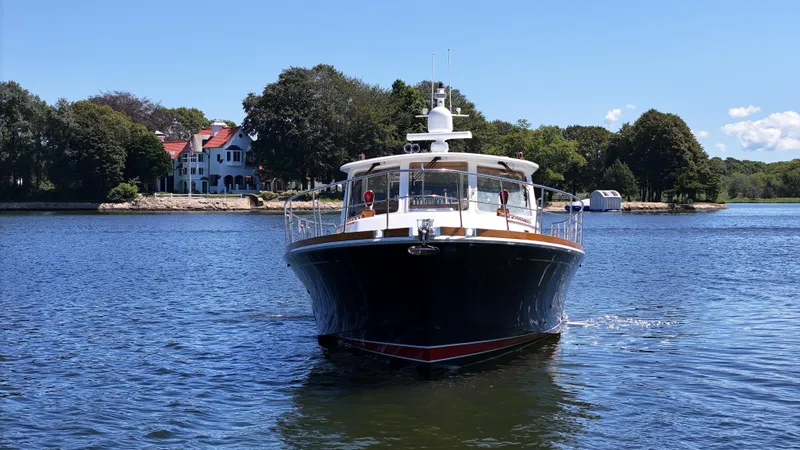 Slide: The Image of 2002 Grand Banks 49 Eastbay HX yacht cruising on a scenic lake. - 5