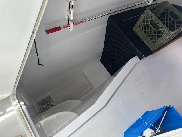 Slide: The Image of 2006 Glacier Bay 2240 SX Renegade boat storage compartment with crate and fishing rod. - 16