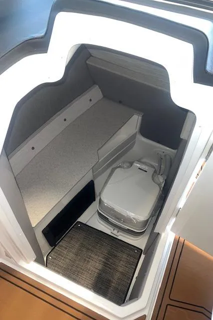 Slide: The Image of 2025 Cobalt R6 Surf boat interior with compact toilet and seating area. - 17
