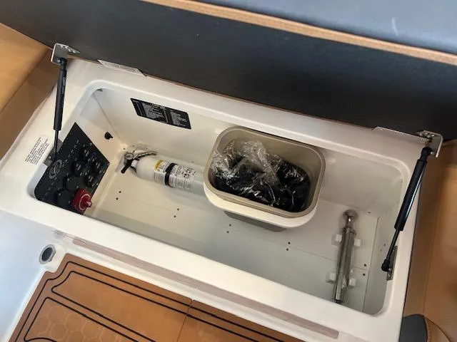 Slide: The Image of Storage compartment in 2025 Cobalt R6 Surf boat with fire extinguisher and accessories. - 24