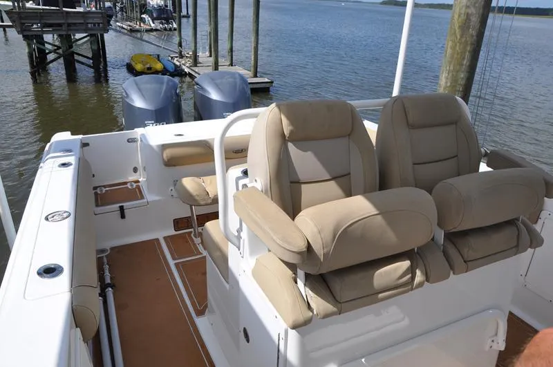 Slide: The Image of 2015 Sea Hunt Gamefish 30 boat interior with dual seats and twin engines docked by the water. - 12