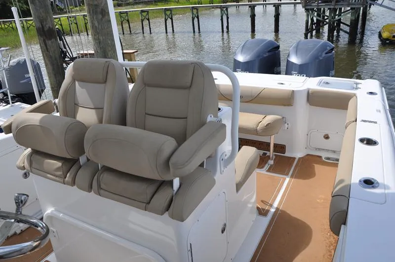 Slide: The Image of 2015 Sea Hunt Gamefish 30 boat interior with cushioned seating and dual outboard motors. - 13