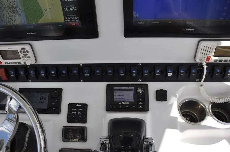Slide: The Image of Control panel of a 2015 Sea Hunt Gamefish 30 boat with navigation screens and switches. - 17