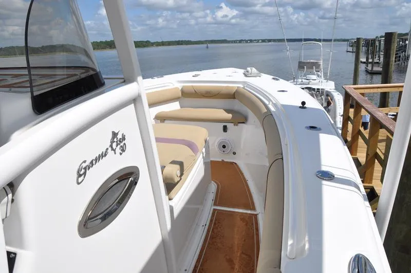 Slide: The Image of 2015 Sea Hunt Gamefish 30 boat docked by a scenic waterfront. - 21