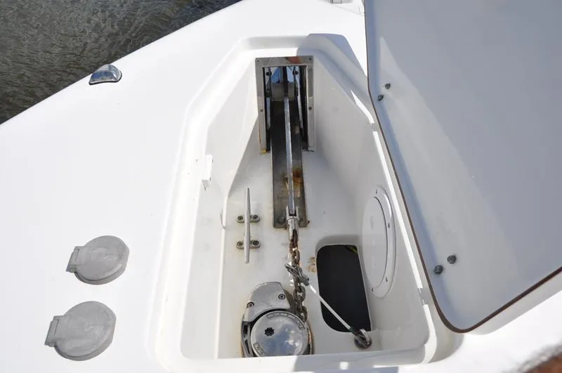 Slide: The Image of Anchor compartment of 2015 Sea Hunt Gamefish 30 boat, open with visible chain and mechanism. - 29