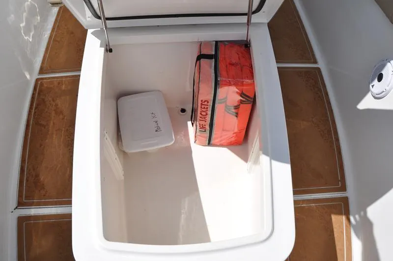 Slide: The Image of Storage compartment on 2015 Sea Hunt Gamefish 30 with life jackets and a medical kit. - 32