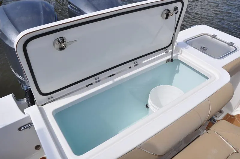 Slide: The Image of Open storage compartment on 2015 Sea Hunt Gamefish 30 boat, featuring a white interior. - 9
