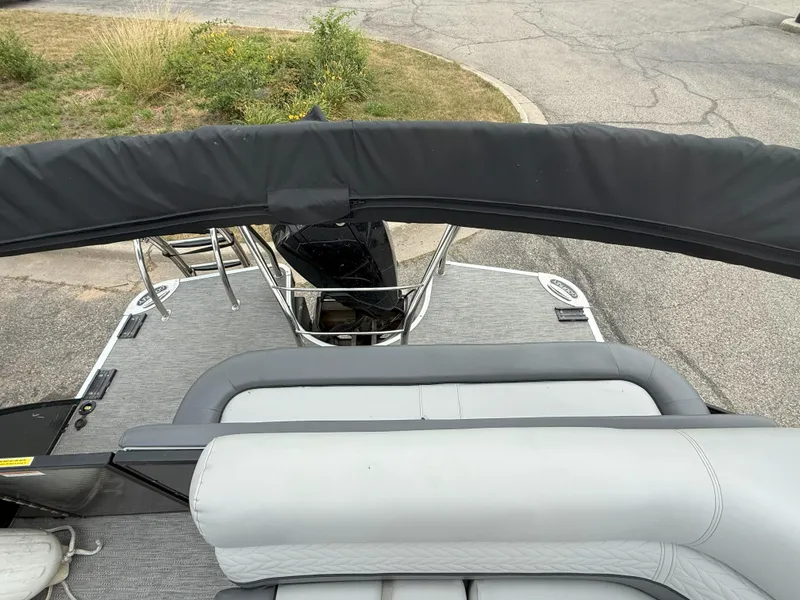 Slide: The Image of 2021 Godfrey Monaco 215 C pontoon boat with gray seating and black canopy. - 11