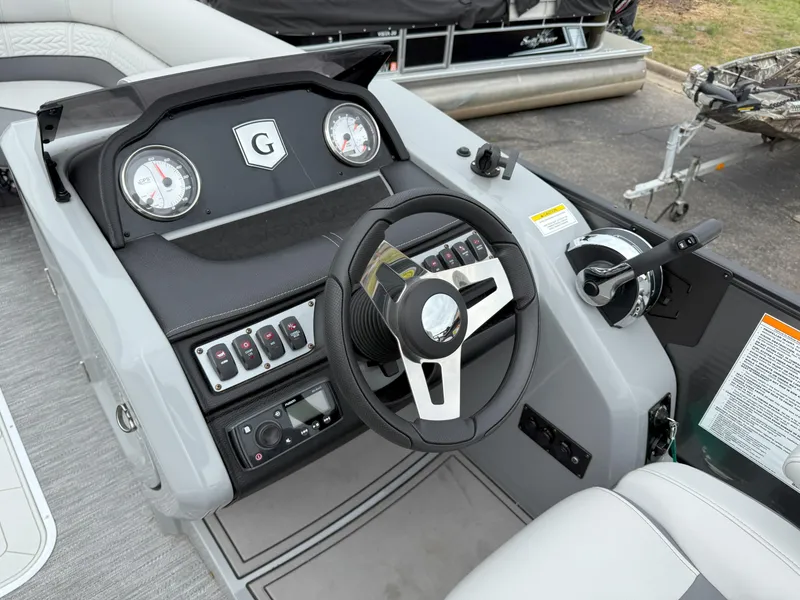 Slide: The Image of 2021 Godfrey Monaco 215 C boat dashboard with steering wheel and control panel. - 12