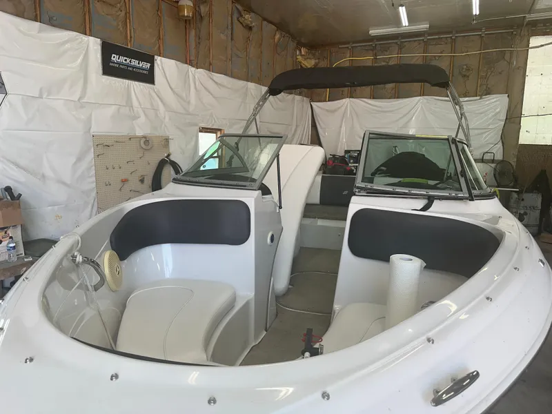 Slide: The Image of 2011 Four Winns H180 boat interior in a garage setting. - 15