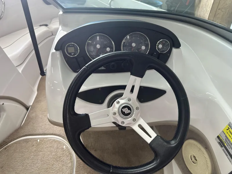 Slide: The Image of Steering wheel and dashboard of 2011 Four Winns H180 boat, featuring gauges and controls. - 5