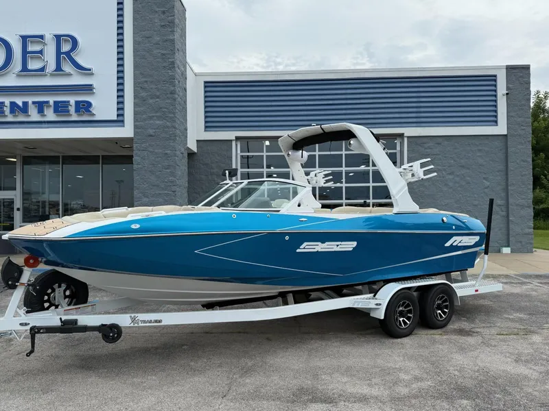 Slide: The Image of 2025 MB B52 23 Classic boat in blue on trailer outside dealership. - 1