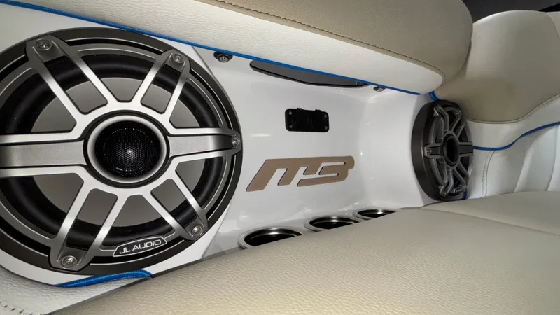 Slide: The Image of Interior of 2025 MB B52 23 Classic with JL Audio speakers and beige seating. - 18