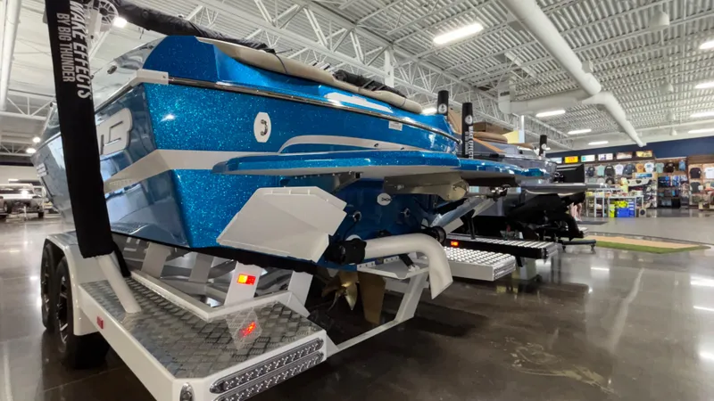 Slide: The Image of 2025 MB B52 23 Classic boat in showroom, blue glitter finish, on trailer. - 5