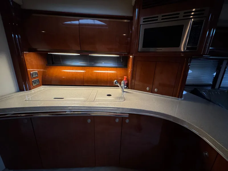 Slide: The Image of Luxurious interior of a 2003 Sea Ray 500 Sundancer yacht with modern kitchen and seating area. - 21