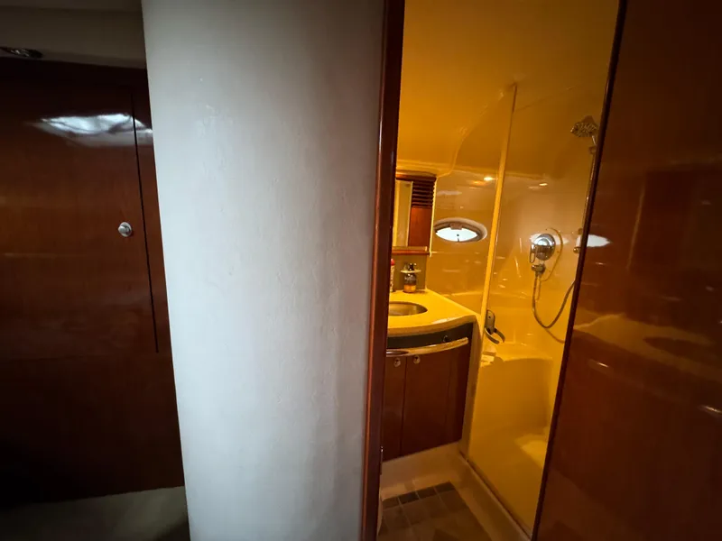 Slide: The Image of Cozy cabin interior of 2003 Sea Ray 500 Sundancer with colorful bedding and wooden cabinetry. - 36