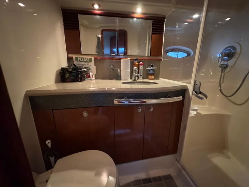 Slide: The Image of Interior of 2003 Sea Ray 500 Sundancer yacht with wooden cabinetry and colorful bedding. - 37