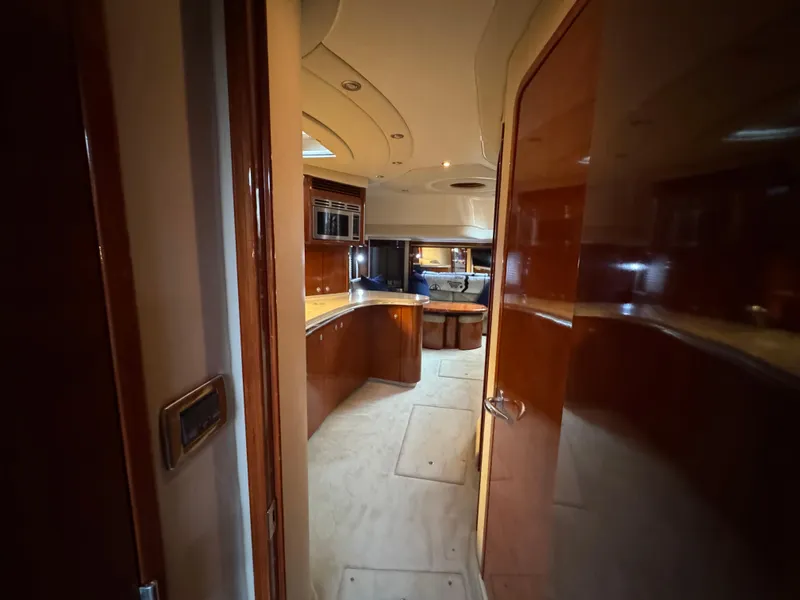 Slide: The Image of Interior of 2003 Sea Ray 500 Sundancer with floral bedding and wooden cabinetry. - 42