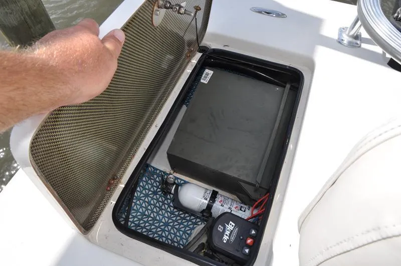 Slide: The Image of Open storage compartment in a 2008 Sterling 180TS boat, revealing equipment and wiring. - 7