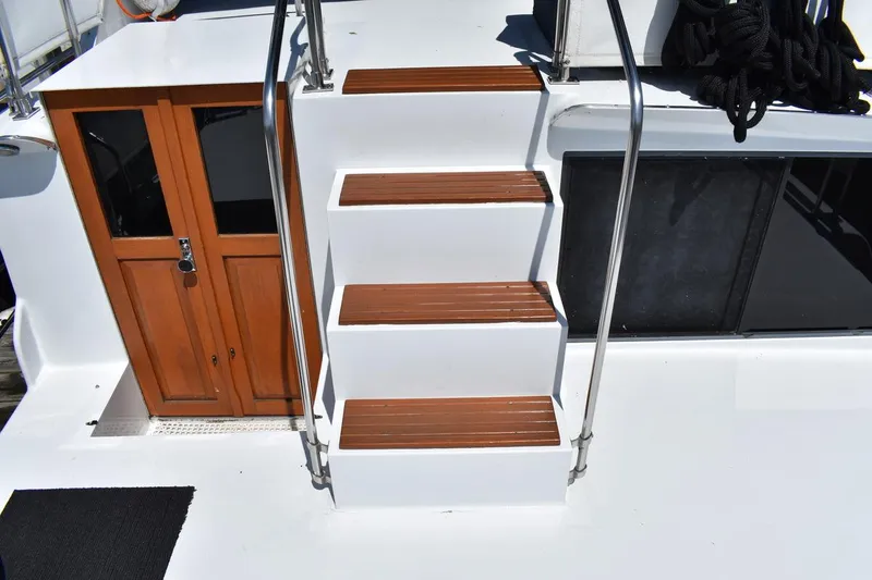 Slide: The Image of Stairs and wooden door on 1985 Marinette 39 Double Cabin boat deck. - 19
