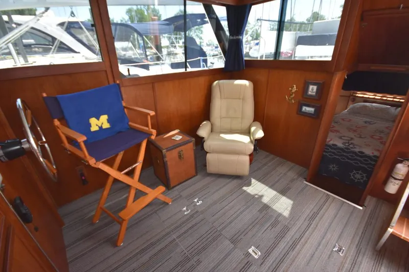 Slide: The Image of 1985 Marinette 39 Double Cabin interior with chairs, nautical decor, and cabin view. - 38