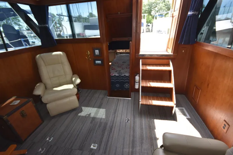 Slide: The Image of 1985 Marinette 39 Double Cabin interior with beige recliner, wooden stairs, and nautical-themed decor. - 39