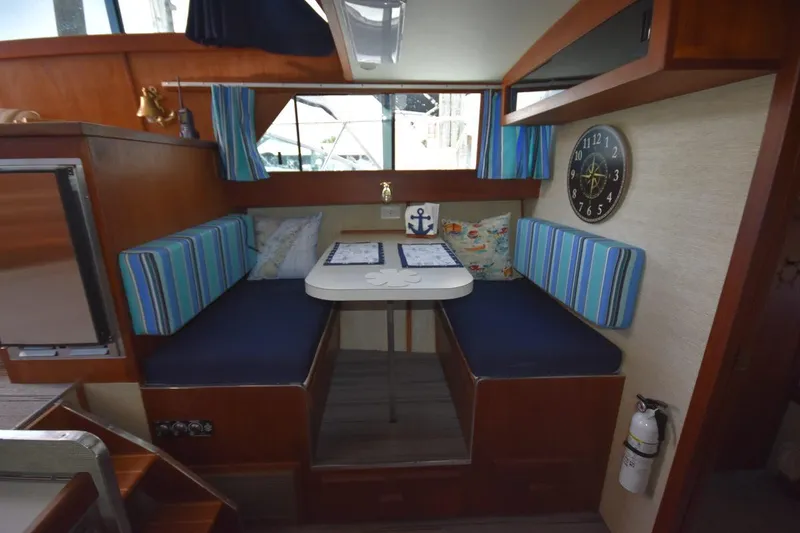 Slide: The Image of 1985 Marinette 39 Double Cabin interior with striped seating, table, and nautical decor. - 46
