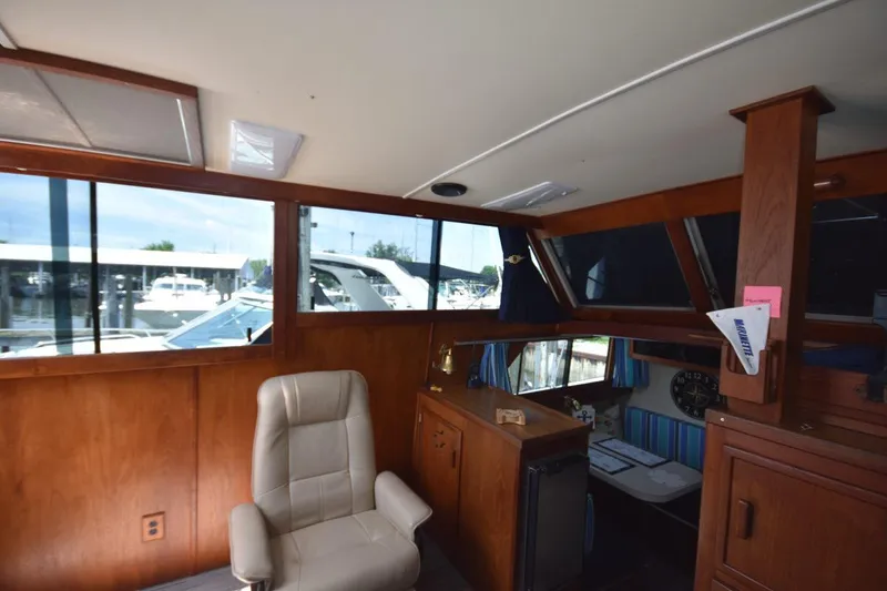 Slide: The Image of 1985 Marinette 39 Double Cabin interior with wood paneling and leather chair, docked at marina. - 42