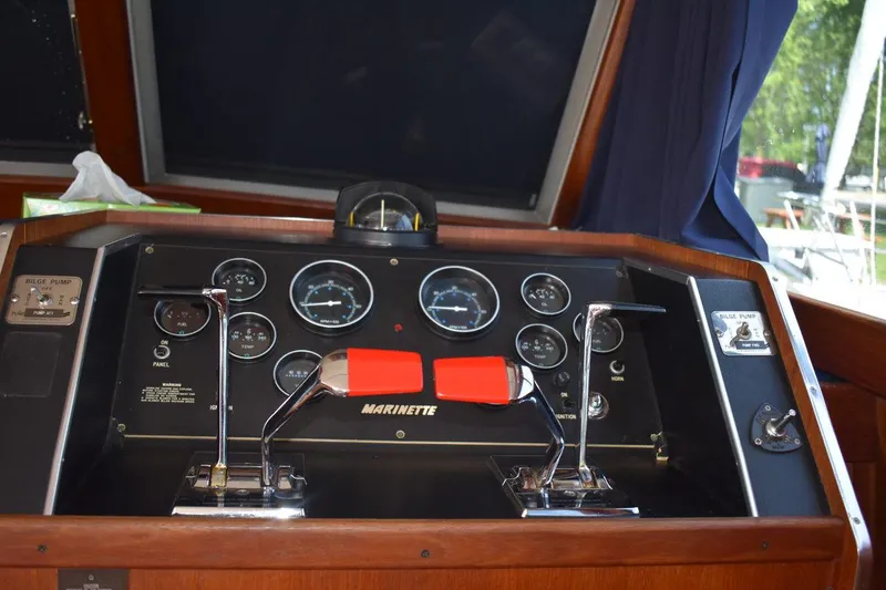 Slide: The Image of Control panel of a 1985 Marinette 39 Double Cabin boat with gauges and levers. - 35