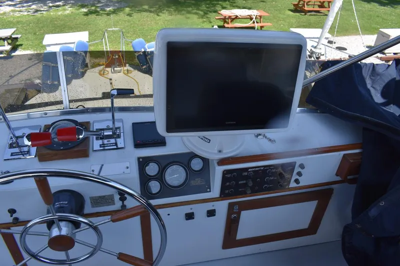 Slide: The Image of Control panel of a 1985 Marinette 39 Double Cabin boat with steering wheel and navigation equipment. - 25