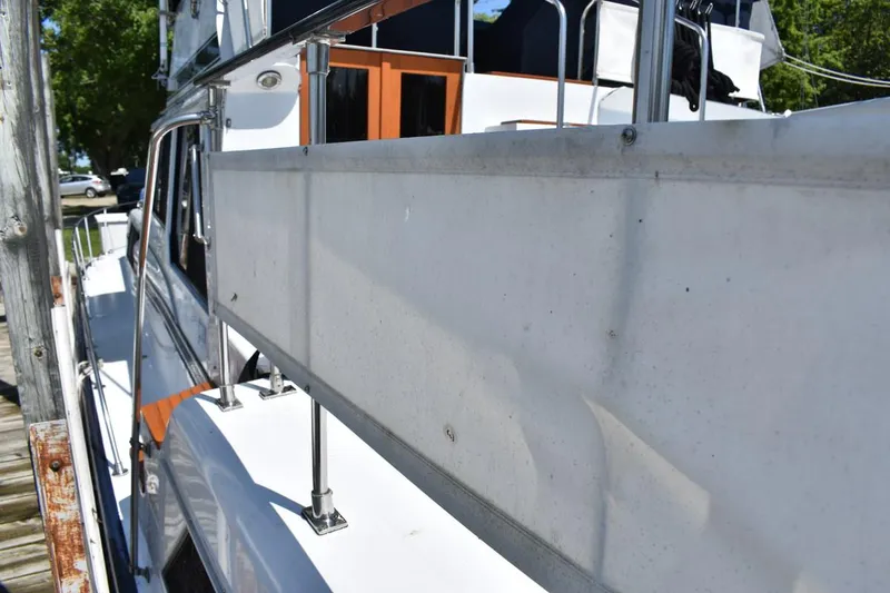 Slide: The Image of 1985 Marinette 39 Double Cabin boat docked, side view with railing and cabin details. - 17