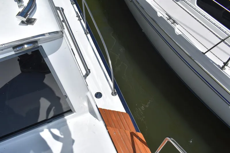 Slide: The Image of 1985 Marinette 39 Double Cabin boat docked, showing deck and railing details. - 21