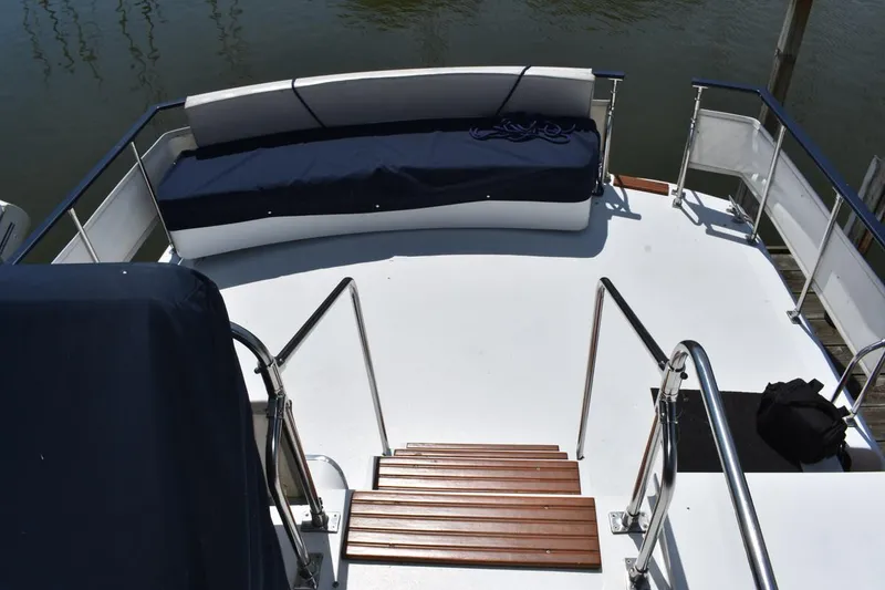 Slide: The Image of 1985 Marinette 39 Double Cabin boat deck with seating and wooden steps. - 31