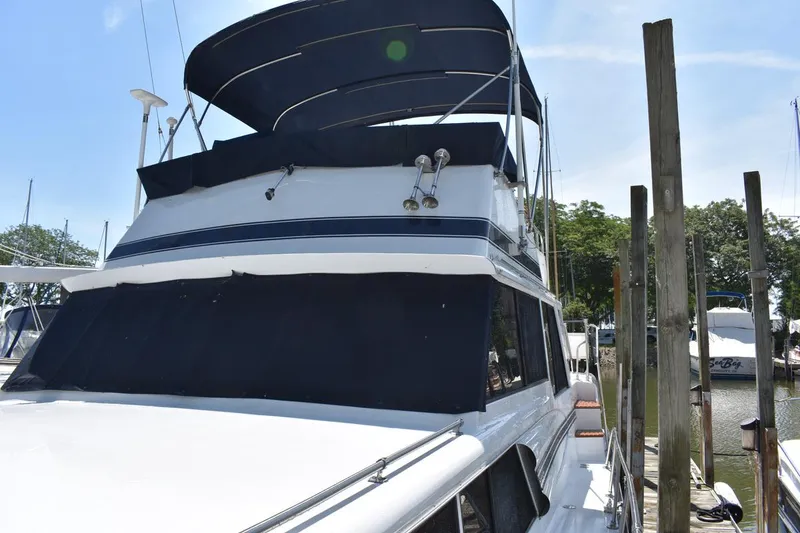 Slide: The Image of 1985 Marinette 39 Double Cabin yacht docked, featuring a sleek design and spacious upper deck. - 10