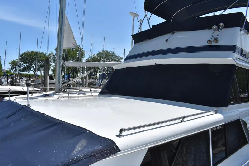 Slide: The Image of 1985 Marinette 39 Double Cabin yacht docked, featuring sleek design and blue canvas covers. - 8