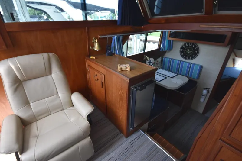 Slide: The Image of 1985 Marinette 39 Double Cabin interior with leather chair, wood cabinetry, and dining area. - 45