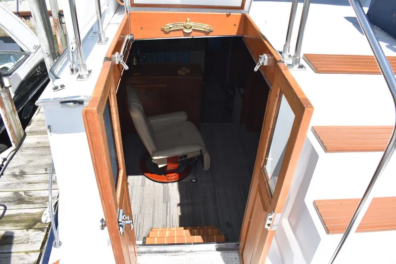 Slide: The Image of 1985 Marinette 39 Double Cabin interior view with open wooden doors and seating. - 34