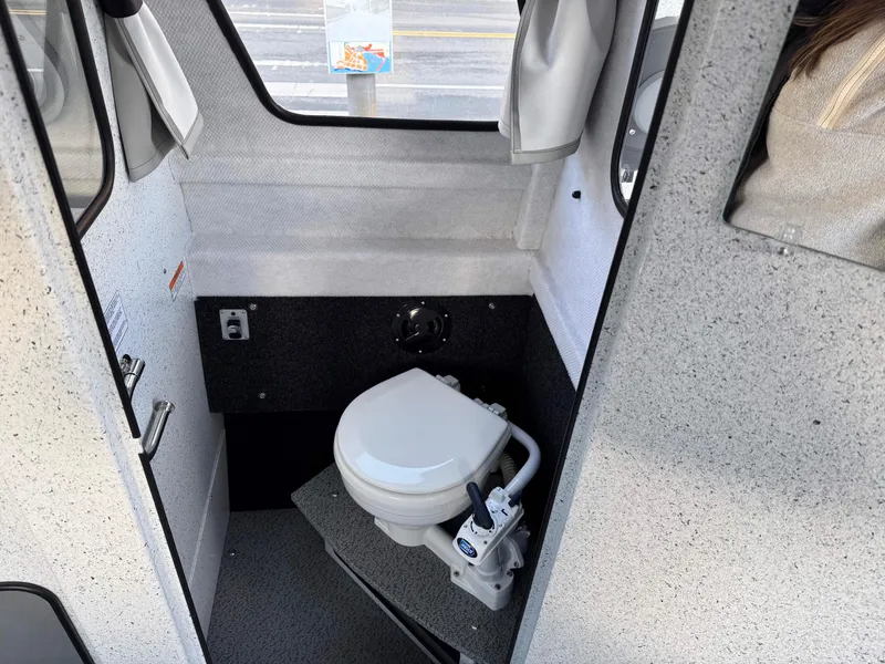 Slide: The Image of Interior of 2025 KingFisher 2825 Coastal Express boat featuring a compact marine toilet. - 11