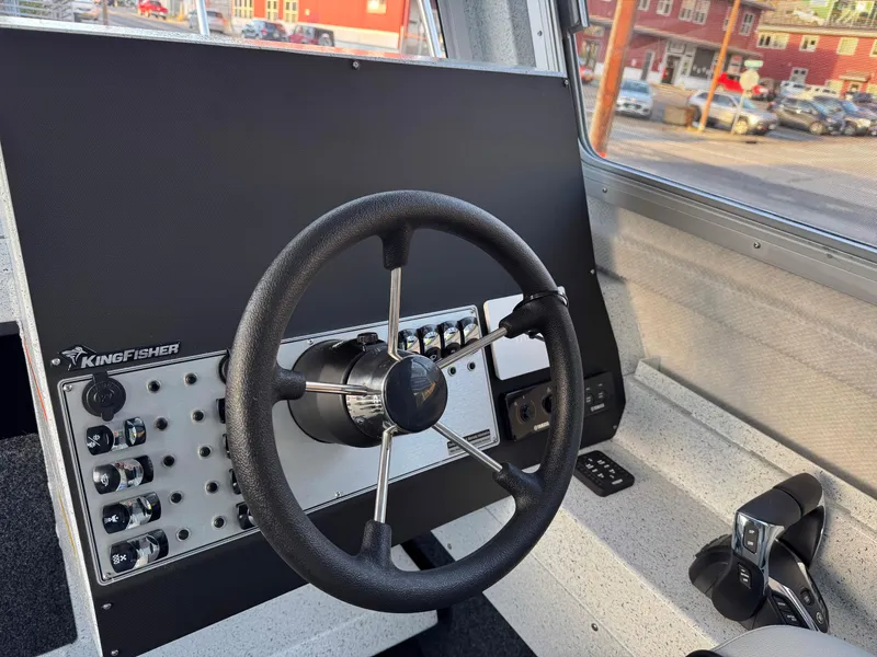 Slide: The Image of 2025 KingFisher 2825 Coastal Express helm with steering wheel and control panel. - 13
