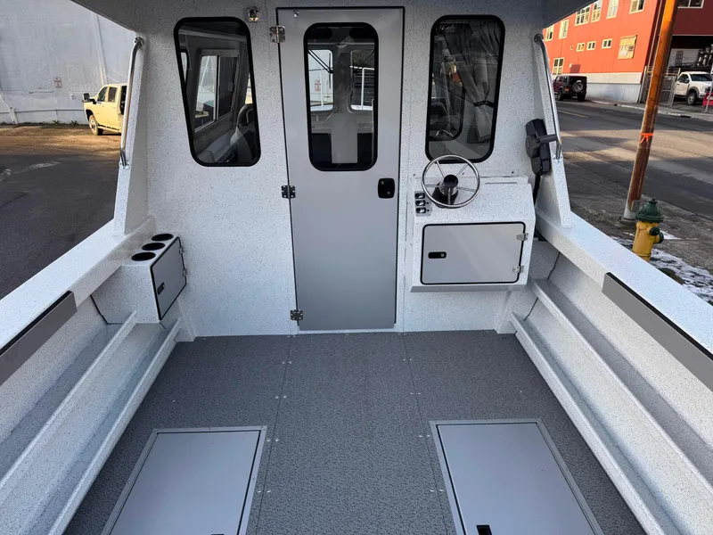 Slide: The Image of 2025 KingFisher 2825 Coastal Express boat interior with steering wheel and storage compartments. - 16