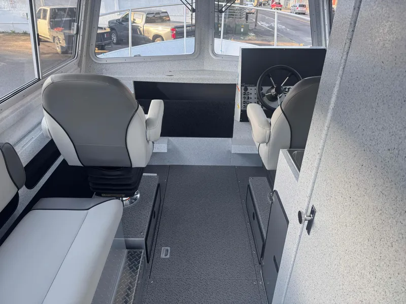 Slide: The Image of Interior of 2025 KingFisher 2825 Coastal Express boat, featuring modern seating and steering area. - 5