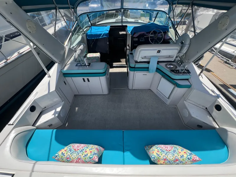 Slide: The Image of 1988 Wellcraft 3400 Grand Sport boat interior with turquoise seating and colorful pillows. - 11