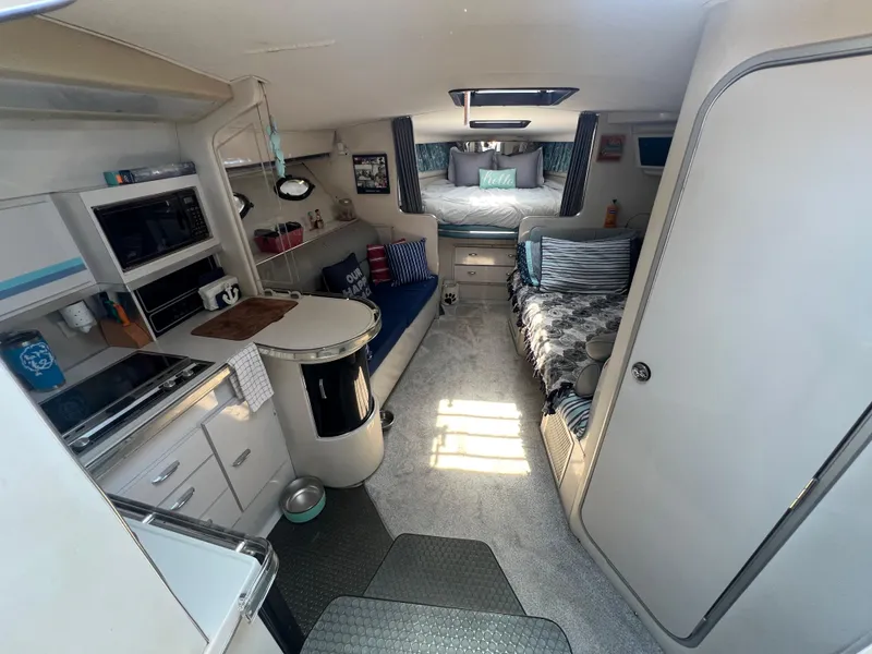 Slide: The Image of Interior of 1988 Wellcraft 3400 Grand Sport boat, featuring cozy living space and kitchen amenities. - 16