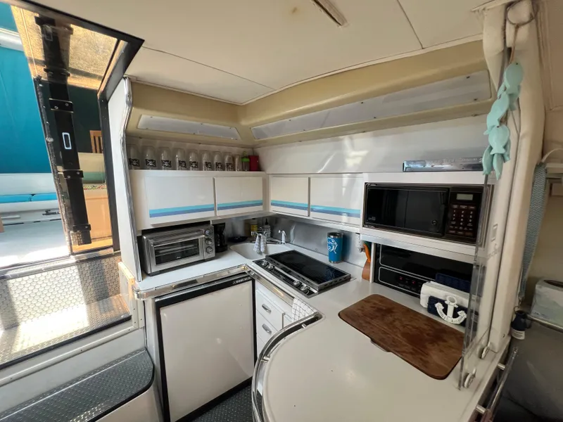 Slide: The Image of 1988 Wellcraft 3400 Grand Sport yacht kitchen with appliances and storage. - 17
