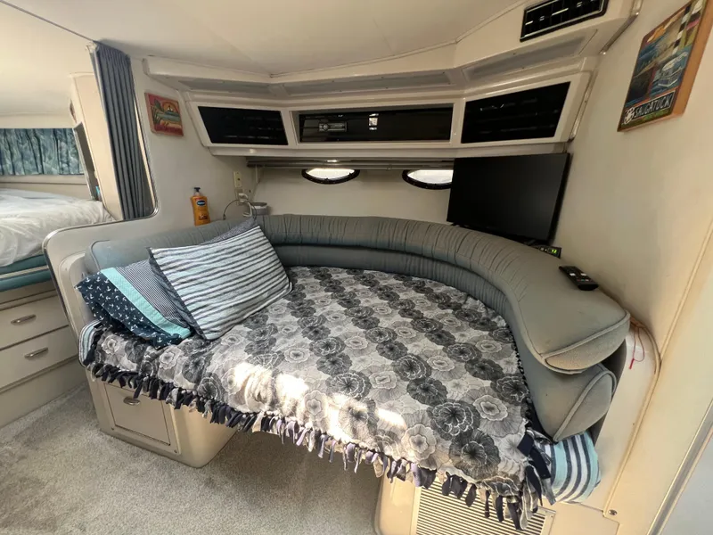 Slide: The Image of 1988 Wellcraft 3400 Grand Sport interior with cozy seating, pillows, and a small TV. - 18