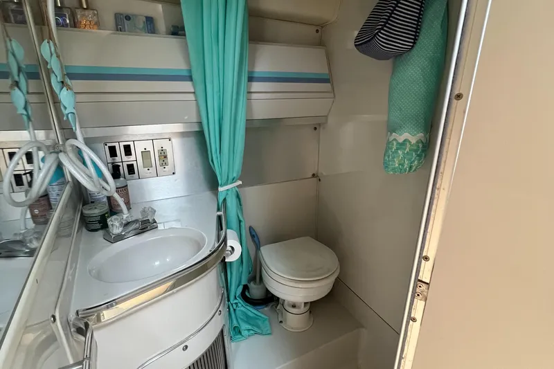 Slide: The Image of 1988 Wellcraft 3400 Grand Sport bathroom with sink, toilet, and teal accents. - 26