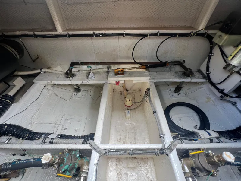 Slide: The Image of Engine compartment of a 1988 Wellcraft 3400 Grand Sport boat, showing mechanical components and wiring. - 32