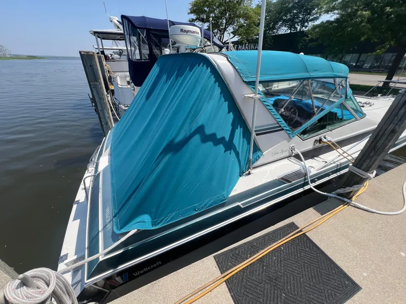 Slide: The Image of 1988 Wellcraft 3400 Grand Sport boat docked with blue canopy cover. - 6